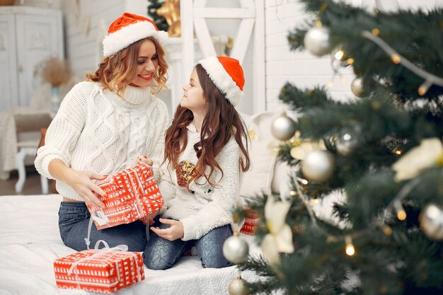 Mother with cute daughter sitting in a room