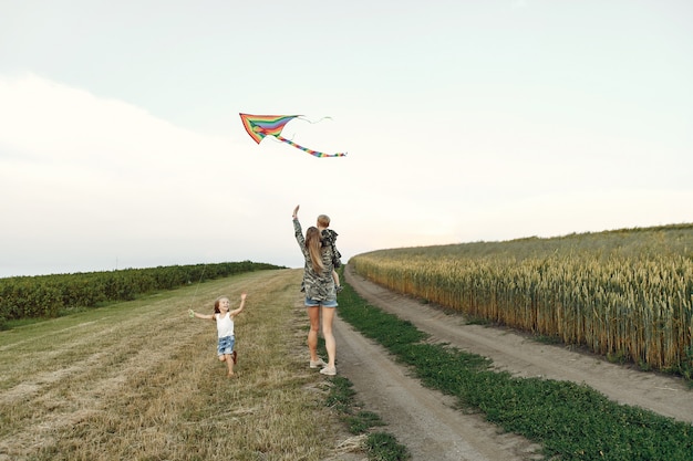 Free photo mother with cute little children in a summer field