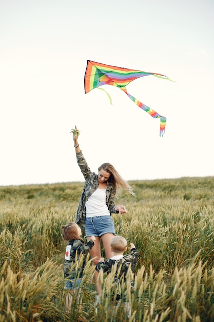 Free photo mother with cute little children in a summer field