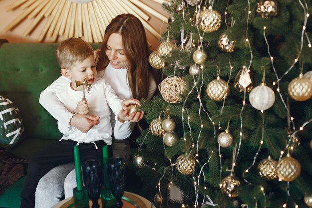 Mother with cute son near christmas tree