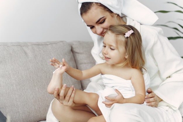 Mother with daughter in bathrobe and towels