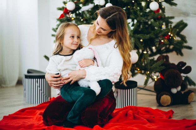 Mother with daughter by christmas tree