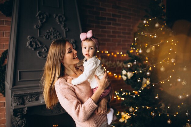 Mother with daughter by Christmas tree