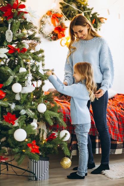 Mother with daughter decorating christmas tree