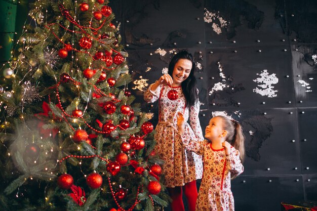 Mother with daughter decorating christmas tree