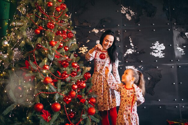 クリスマスツリーを飾る娘を持つ母