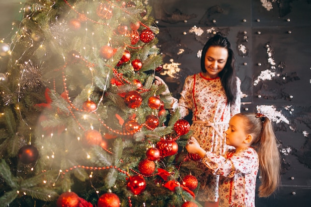Mother with daughter decorating christmas tree