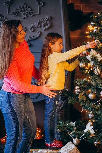 Mother with daughter decorating Christmas tree
