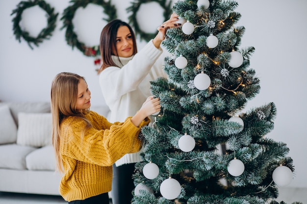 Mother with daughter decorating christmas tree