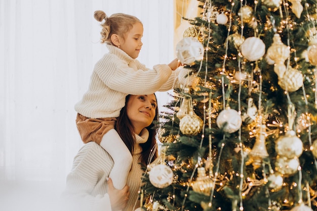 Madre con figlia che decora l'albero di natale