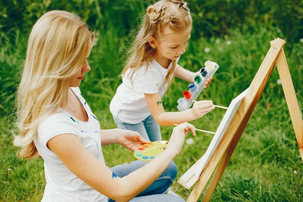 Mother with daughter drawing in a park