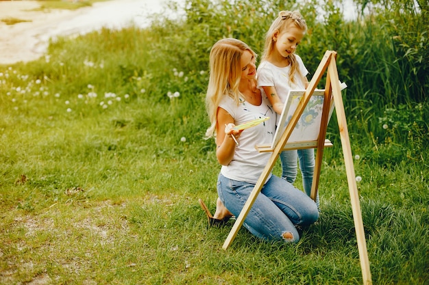 Mother with daughter drawing in a park