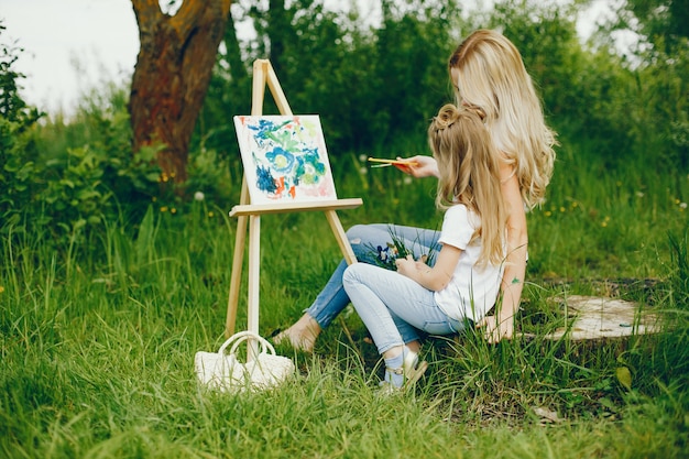 Mother with daughter drawing in a park