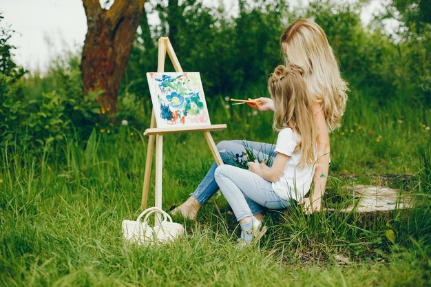 Mother with daughter drawing in a park