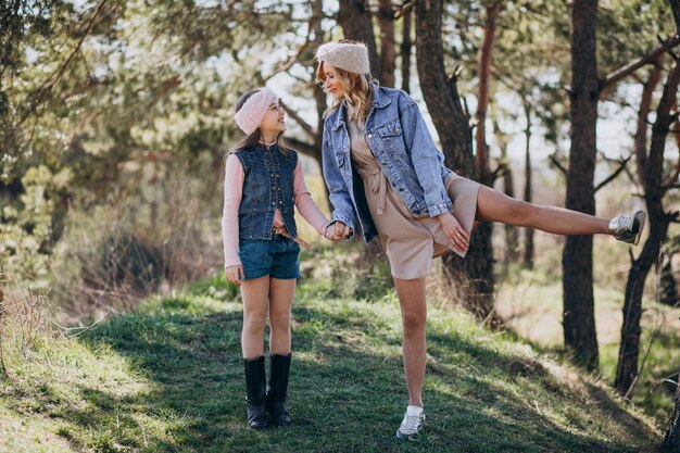 Mother with daughter having fun in the forest