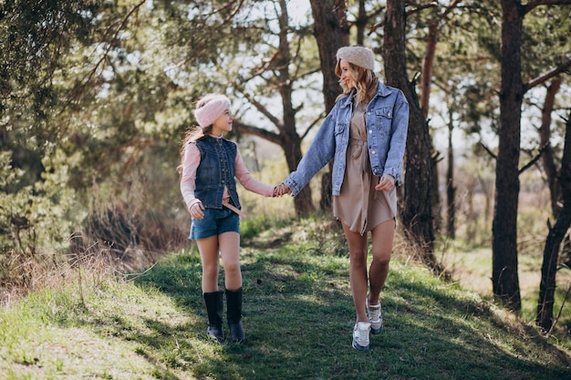 Mother with daughter having fun in the forest