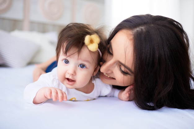 The mother with daughter lie on the bed and dog looking at them