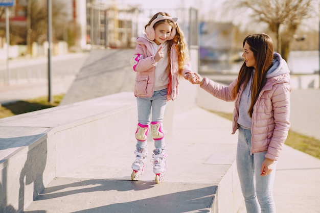 Mother with daughter in a park with roller