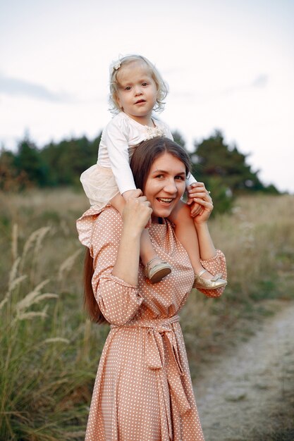 Мать с дочерью, играя в осеннем поле