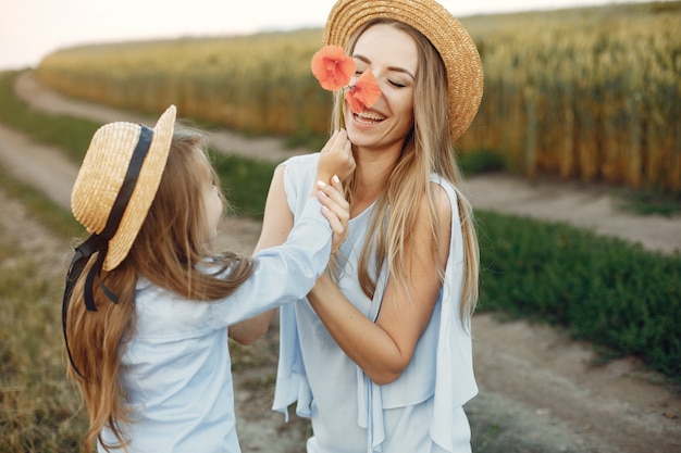 夏の畑で遊ぶ娘を持つ母