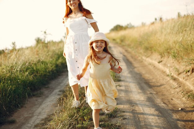 Mother with daughter playing in a summer field
