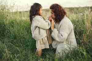 Free photo mother with daughter playing in a summer field