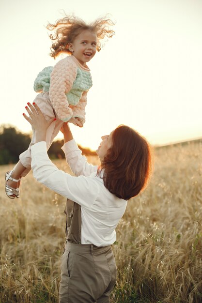 Мать с дочерью, играя в летнем поле