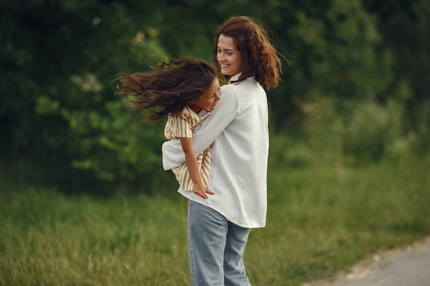 Free photo mother with daughter playing in a summer field