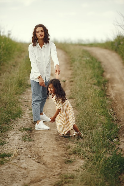 Мать с дочерью, играя в летнем поле