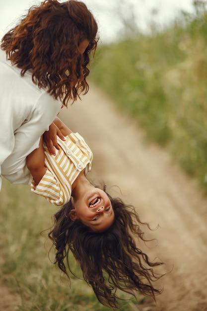 Free photo mother with daughter playing in a summer field