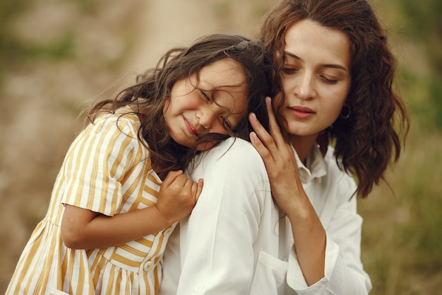 Madre con figlia che gioca in un campo estivo