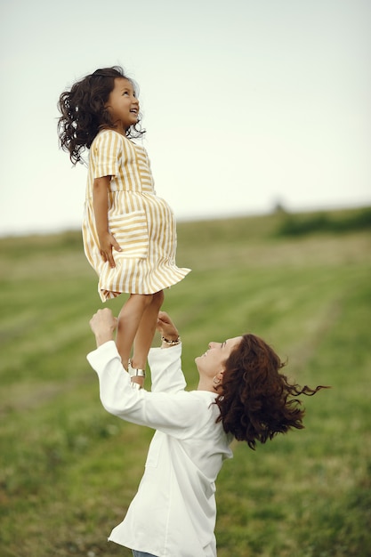 Mother with daughter playing in a summer field