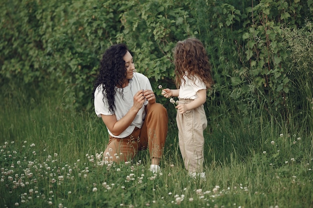 Mother with daughter playing in a summer field