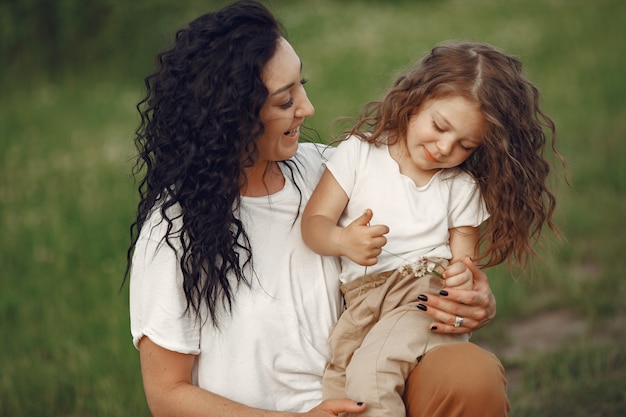 Madre con figlia che gioca in un campo estivo