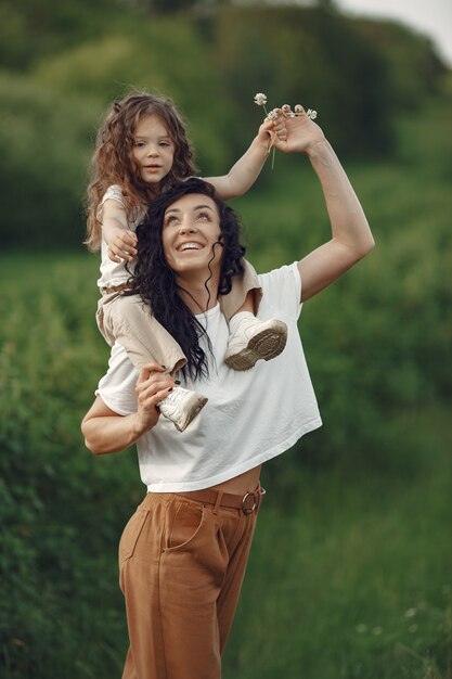 Mother with daughter playing in a summer field