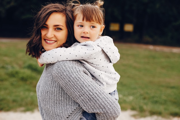 Free photo mother with daughter playing in a summer park