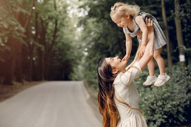 Mother with daughter playing in a summer park