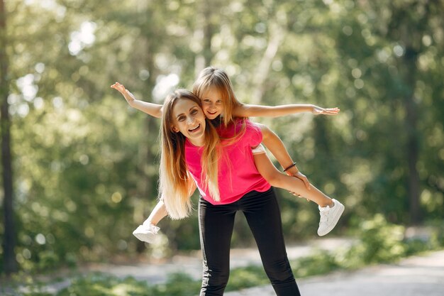 Mother with daughter playing in a summer park