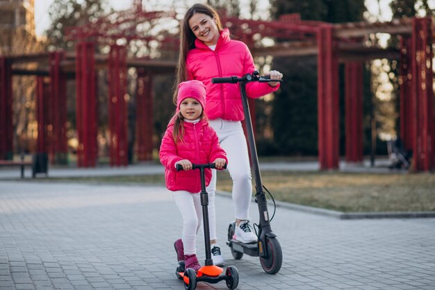 Mother with daughter riding electric scooter