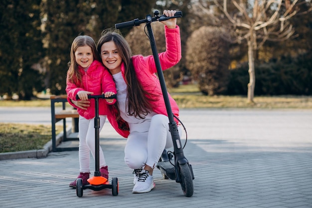 Mother with daughter riding electric scooter