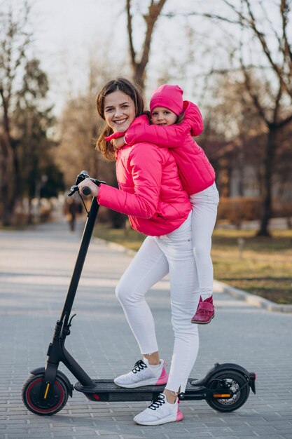 Mother with daughter riding electric scooter