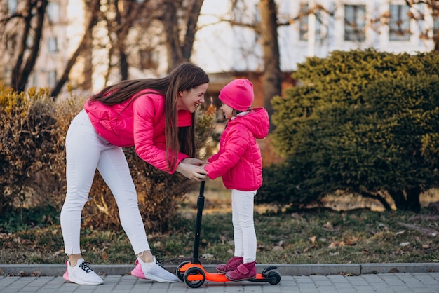 Mother with daughter riding electric scooter