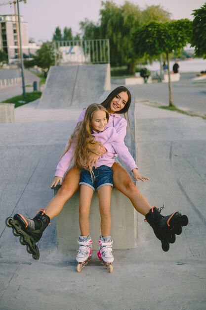 Mother with daughter rollerskating in park with lake