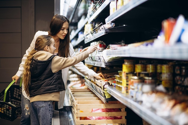 Мать с дочерью делает покупки в продуктовом магазине