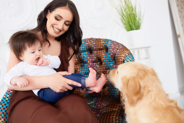 La madre con la figlia che si siede sulla sedia vicino al cane