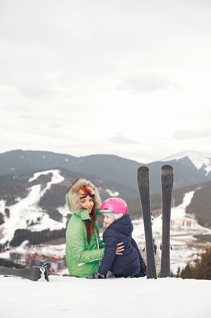 Mother with daughter skiing. People in the snowy mountains.