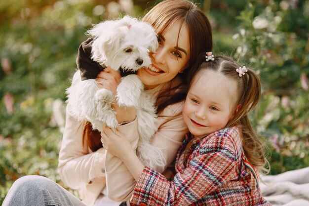 Mother with daughter in a spring forest with dog