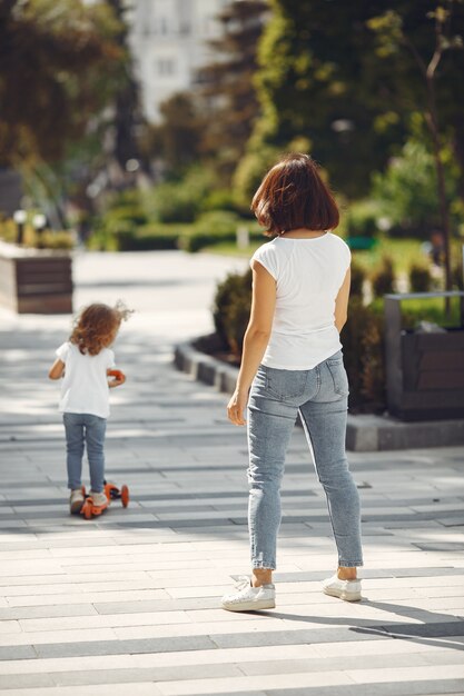 Mother with daughter in a spring park with skate