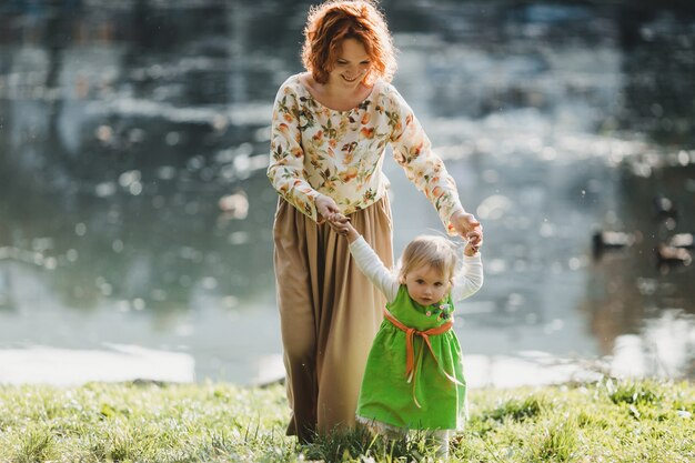 The mother with daughter walking near lake