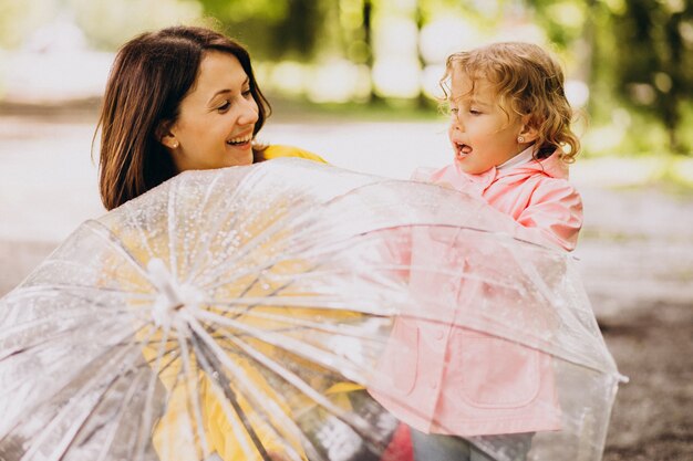 우산 아래 빗 속에서 산책하는 딸과 어머니